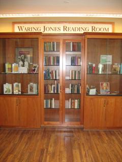 Warning Jones Reading Room over a wooden bookcase full of books.